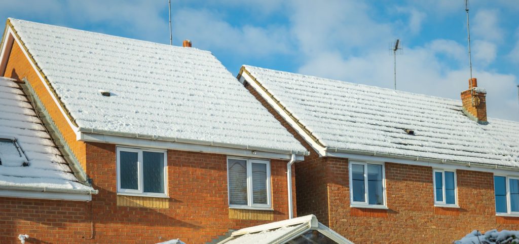New build UK homes with snow covering roof