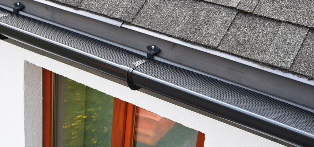 house using a gutter guard to protect gutter and drain pipe