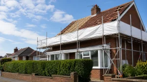 Brick house roof replacement with gutters and fascias protected by scaffolding.