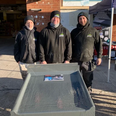 3 acorn roofing workers stood outside in branded jackets